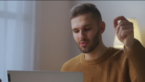 Mann-Spricht-Und-Gestikuliert-Bei-Videokonferenz-Und-Schaut-Auf-Bildschirm-Und-Webcam-Eines-Laptops.-Porträt-Einer-Person-Im-Raum,-Die-Per-Fernzugriff-Arbeitet.